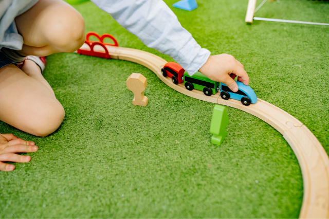bambino gioca con il treno di legno per la rivista di play therapy italia